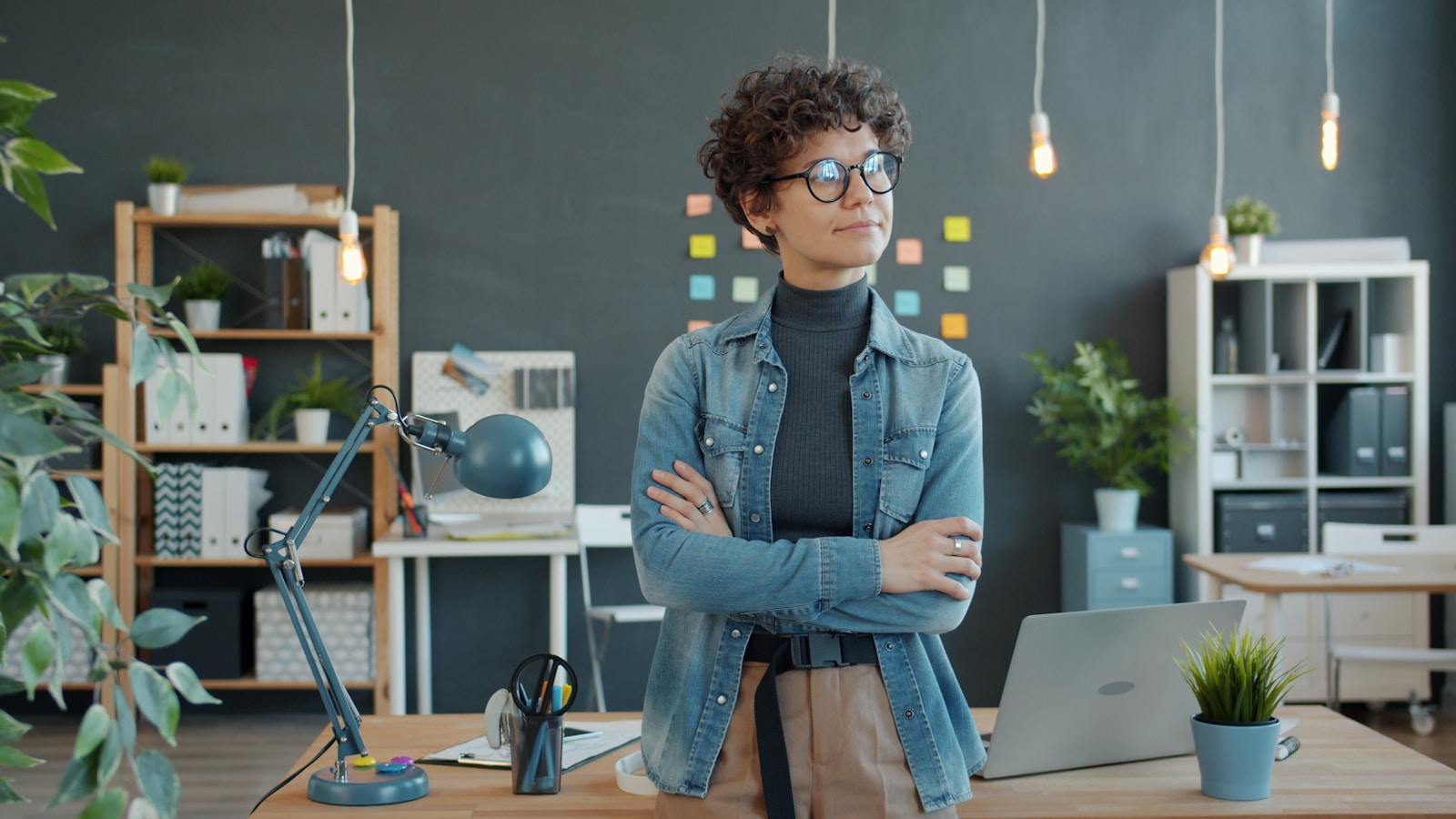 Woman standing with arms crossed in modern office